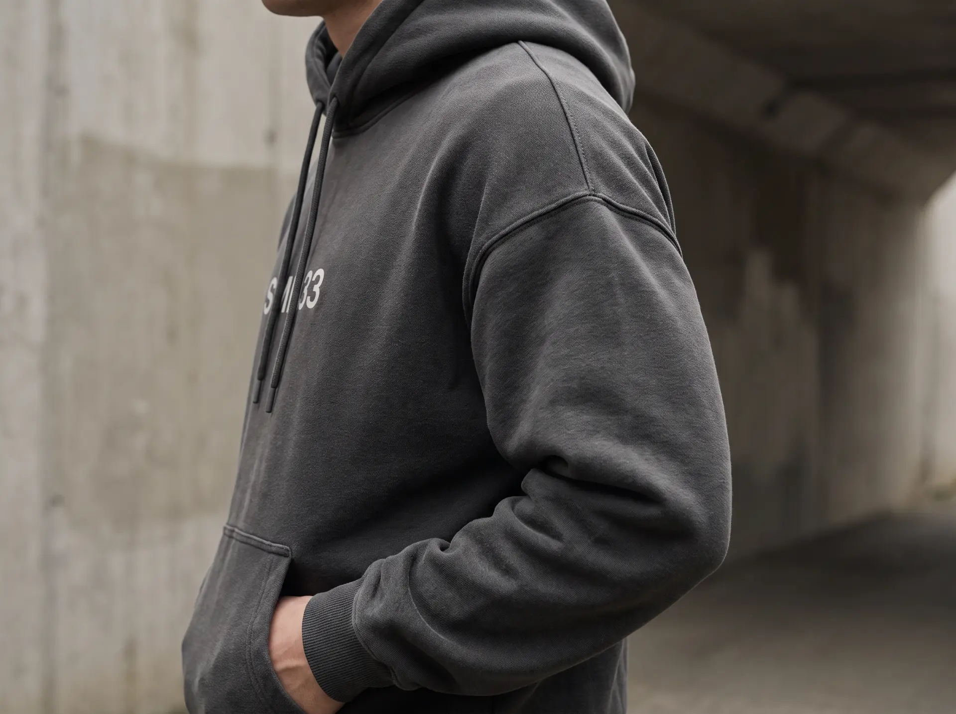 Detalle de tejido y construcción de una sudadera con capucha gris