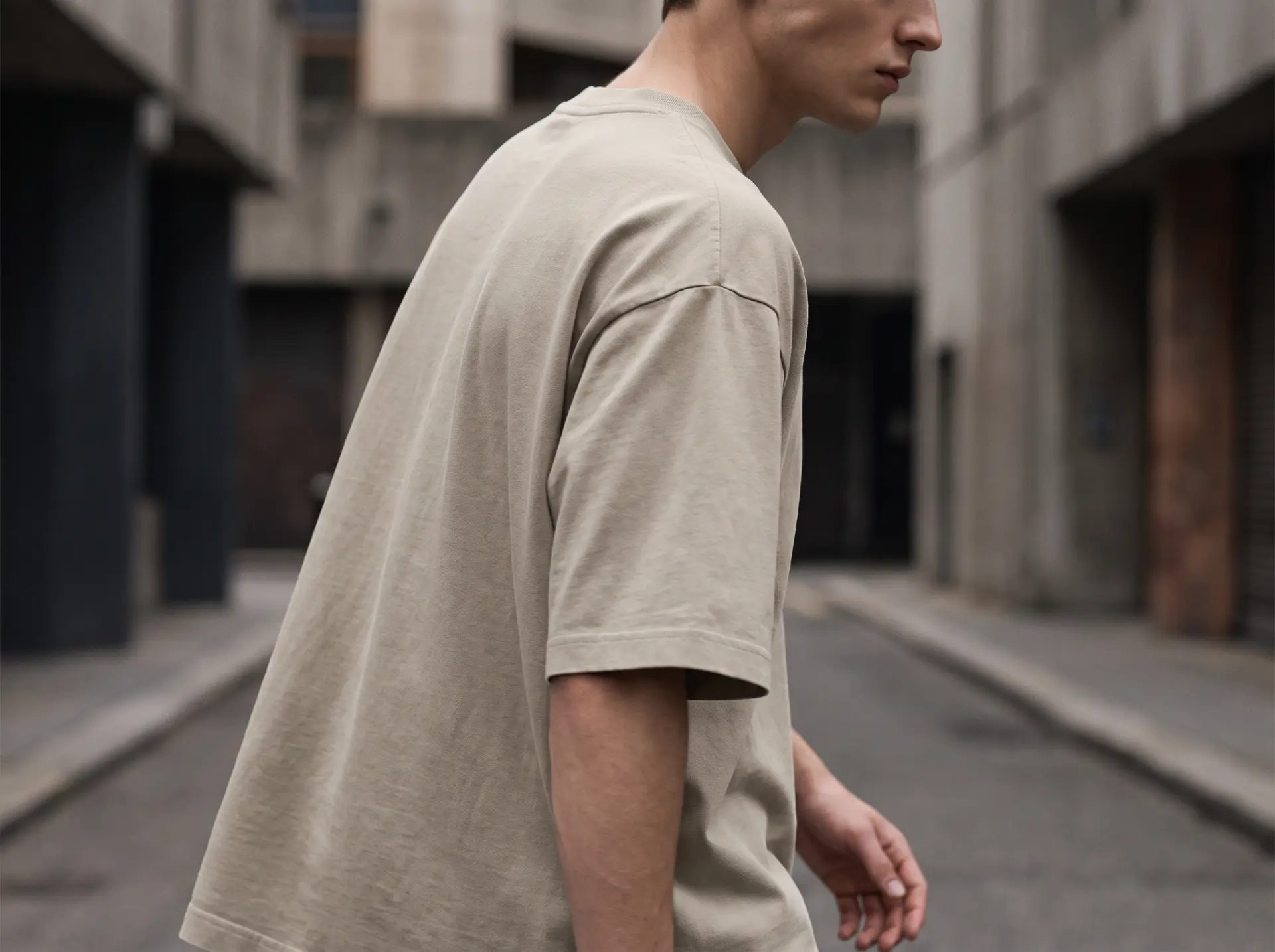Vista lateral de una camiseta de tono neutro en un entorno urbano